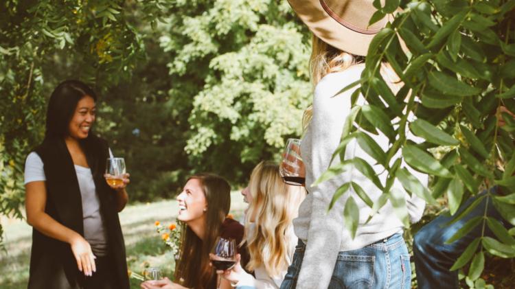 People gathered in the woods enjoying drinks