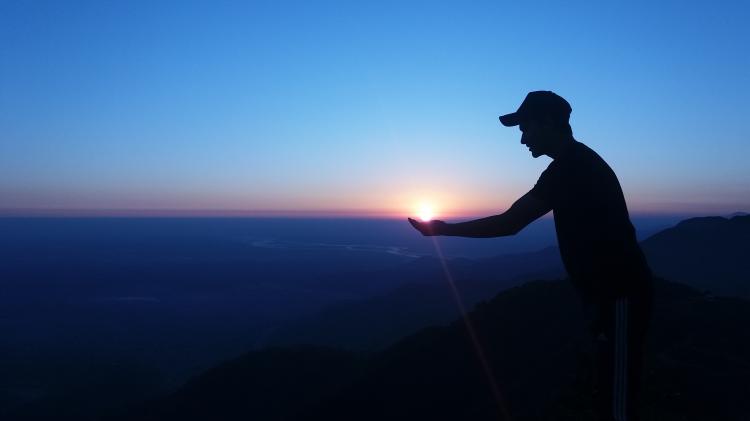 Image of person holding the sunset.